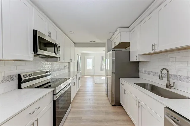 a kitchen with stainless steel appliances granite countertop a sink stove and refrigerator