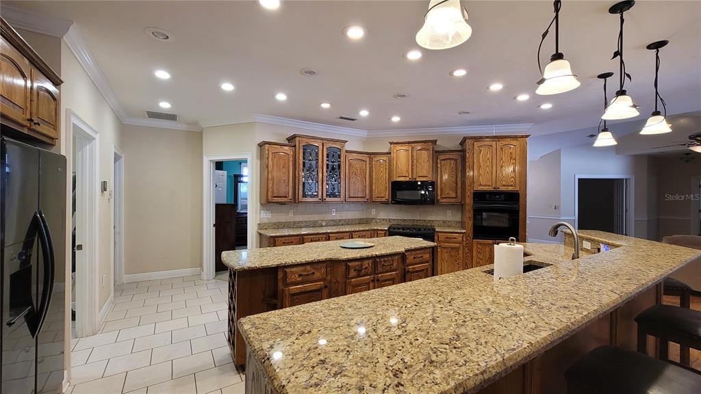 8762 Highway 26 Newberry, FL 32669 - Photo 17 of 63 a large kitchen with kitchen island a large counter top space a sink stainless steel appliances and cabinets