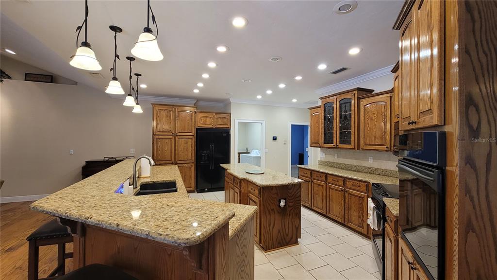 8762 Highway 26 Newberry, FL 32669 - Photo 19 of 63 a kitchen with stainless steel appliances granite countertop a sink dishwasher and a refrigerator with wooden floor