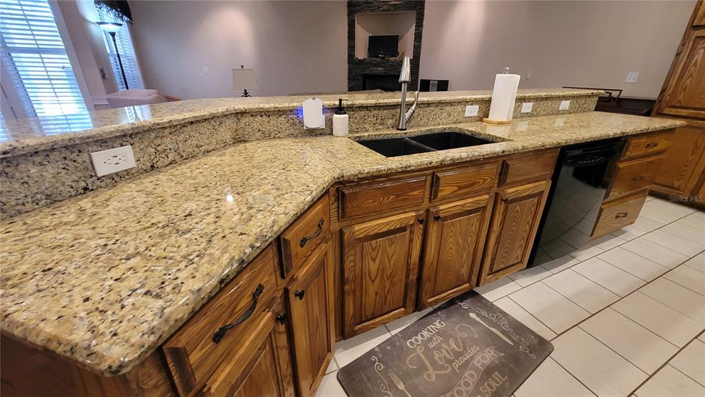 8762 Highway 26 Newberry, FL 32669 - Photo 41 of 63 a bathroom with a granite countertop sink and a wooden cabinets