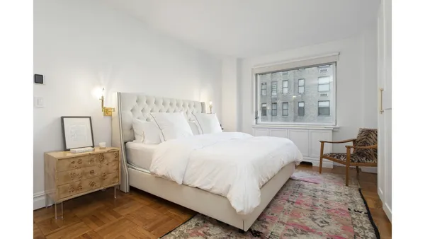 a large bed sitting in a bedroom next to a window with lamp
