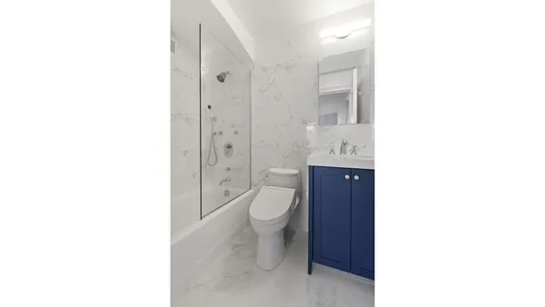 a bathroom with a toilet a sink a mirror and a shower