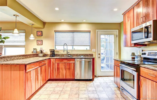 a large kitchen with stainless steel appliances granite countertop a stove a sink and a refrigerator
