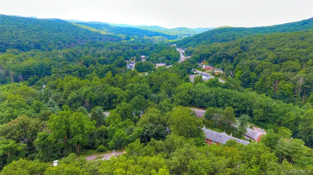 a view of a lush green forest with a house