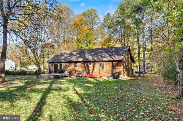 a view of a brick house with a big yard and large trees