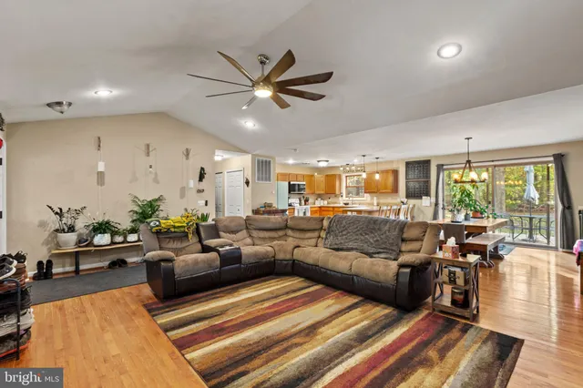 a living room with furniture kitchen view and a large window