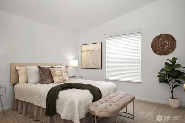 a bedroom with a bed and a potted plant