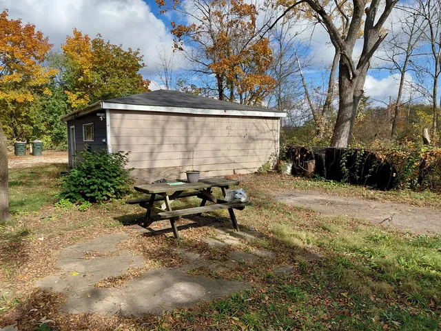 a view of a bench in the patio next to a yard