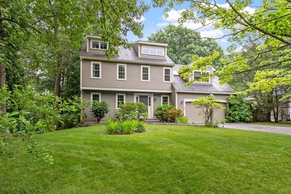 a front view of a house with a yard and trees