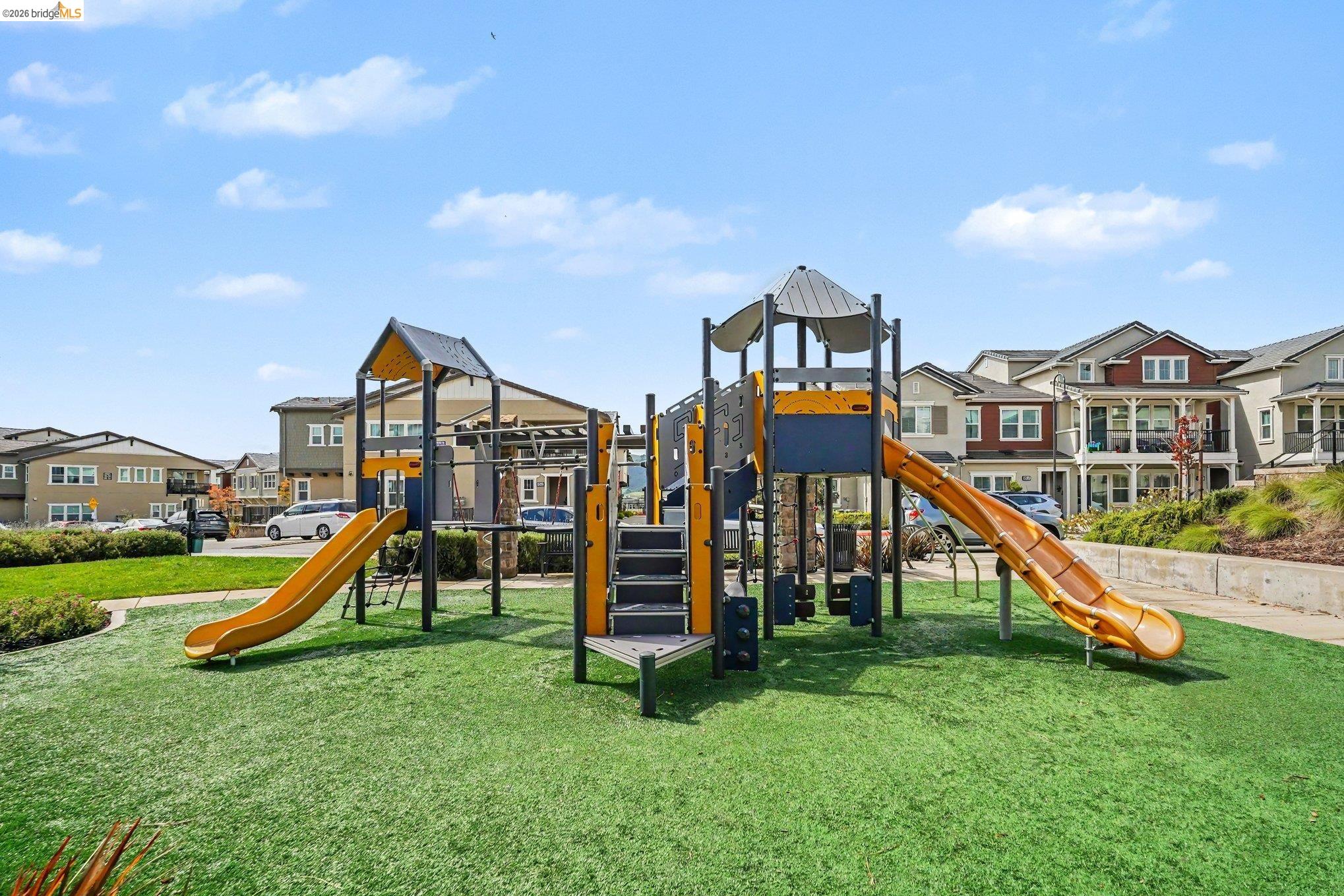 18210 Argento Loop San Ramon, CA 94583 - Photo 31 of 44 Community playground featuring multiple slides, climbing elements, and a soft-surface ground cover