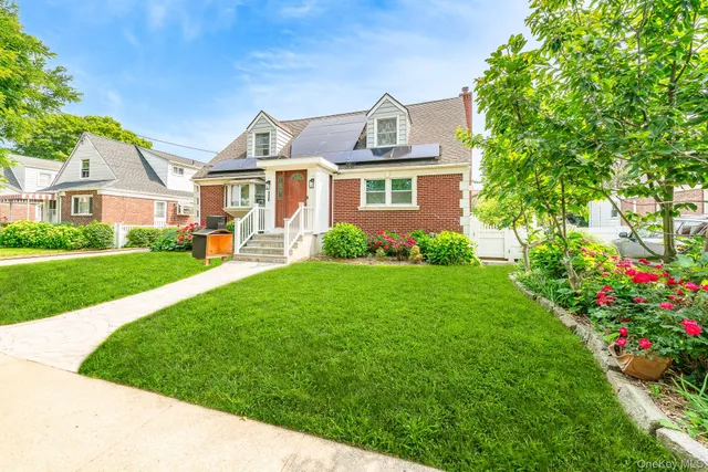 a front view of a house with a garden