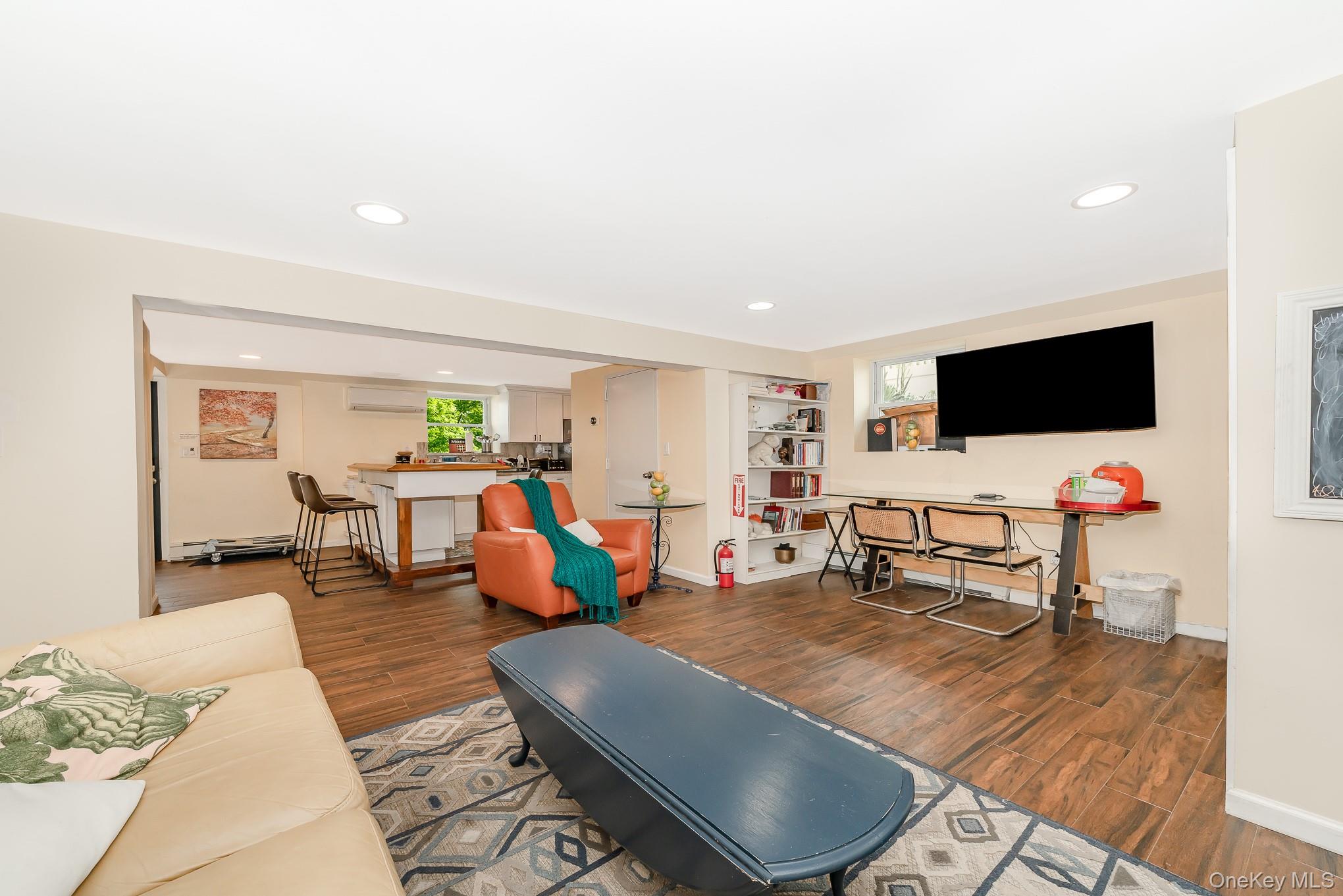 136 Wardwell Road Mineola, NY 11501 - Photo 14 of 25 Living area featuring wood finished floors, recessed lighting, baseboards, and a wall unit AC