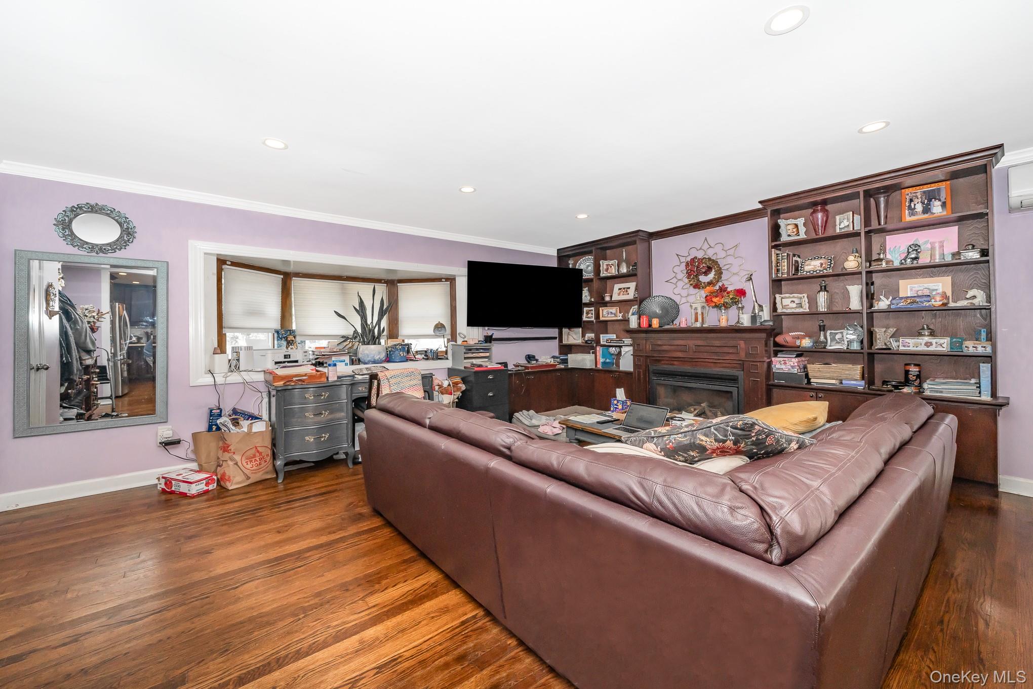 136 Wardwell Road Mineola, NY 11501 - Photo 21 of 25 Living room featuring crown molding, wood finished floors, a fireplace, baseboards, and recessed lighting