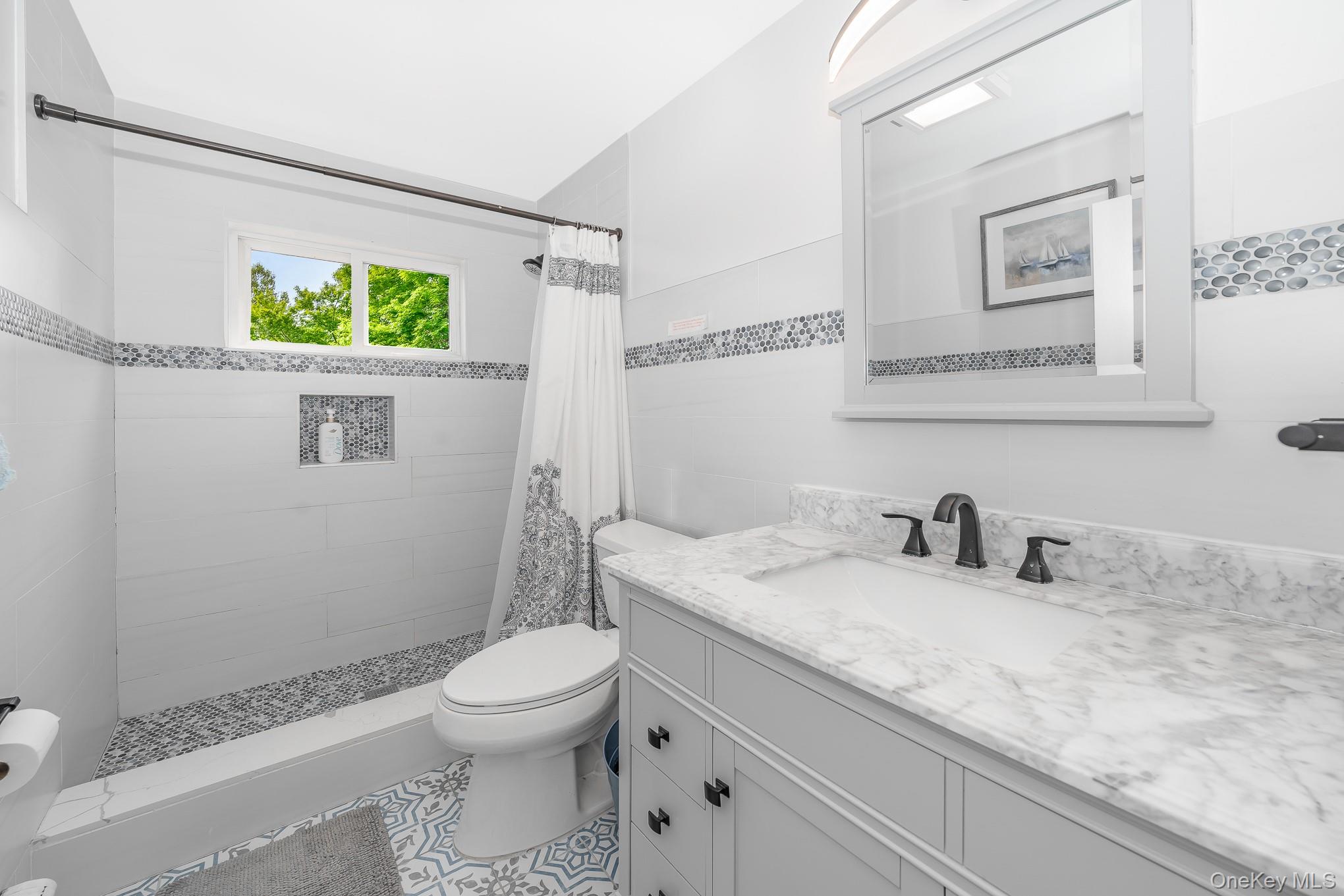 136 Wardwell Road Mineola, NY 11501 - Photo 23 of 25 Full bathroom with toilet, vanity, tiled shower, and tile patterned floors