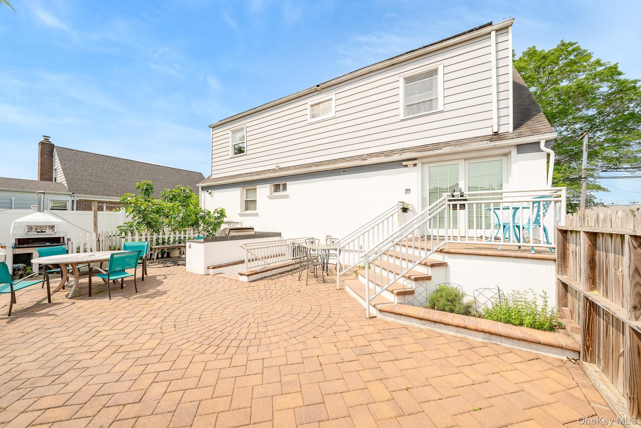 136 Wardwell Road Mineola, NY 11501 - Photo 4 of 25 Rear view of property featuring a patio area and outdoor dining area