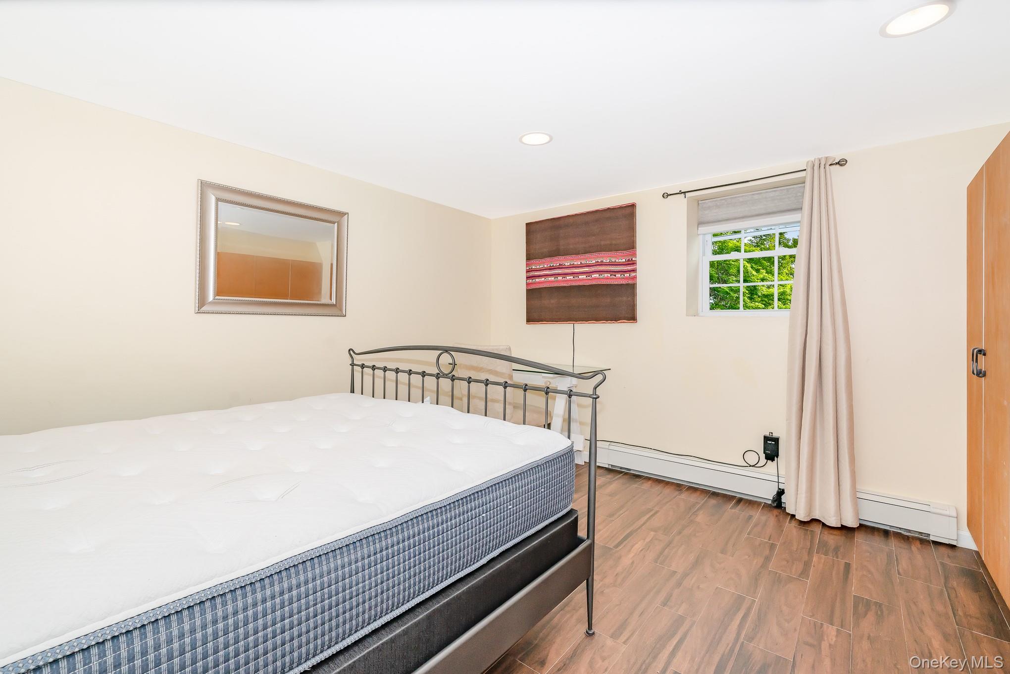 136 Wardwell Road Mineola, NY 11501 - Photo 10 of 25 Bedroom with wood finished floors, recessed lighting, and a baseboard heating unit