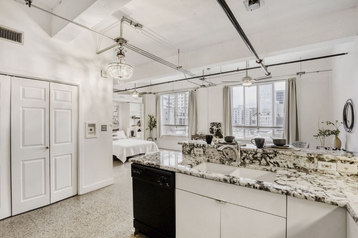 710 Colorado Street, Unit 4G Austin, TX 78701 - Photo 11 of 39 Tall, under-lit upper cabinets and a built-in pantry provide smart storage, and all appliances convey, including a front-load washer and dryer.