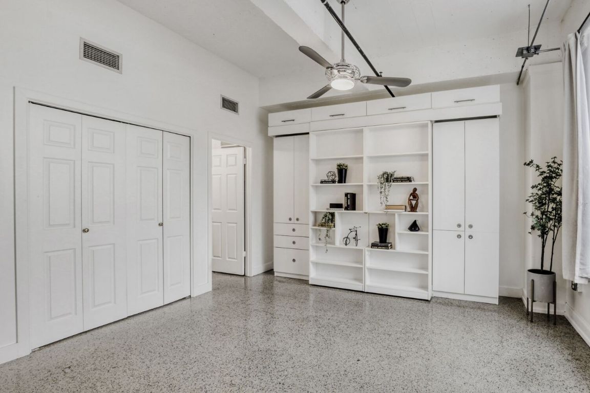 710 Colorado Street, Unit 4G Austin, TX 78701 - Photo 12 of 39 The open studio-style bedroom flows seamlessly into the living area and features a refined Murphy bed with overhead storage and side bookcases.