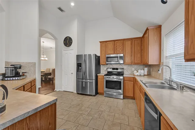 a kitchen with a sink a refrigerator and a stove top oven