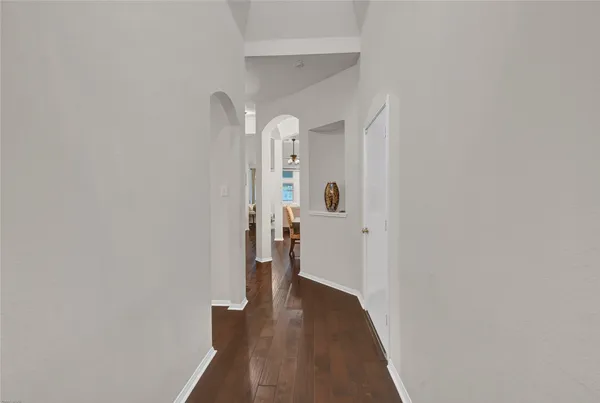 a view of a hallway with wooden floor and staircase