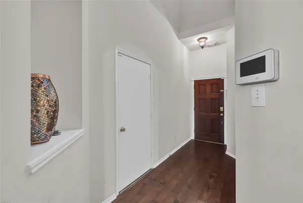 a view of a hallway with wooden floor and cabinet