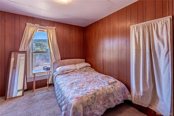 a bed sitting in a bedroom next to a window