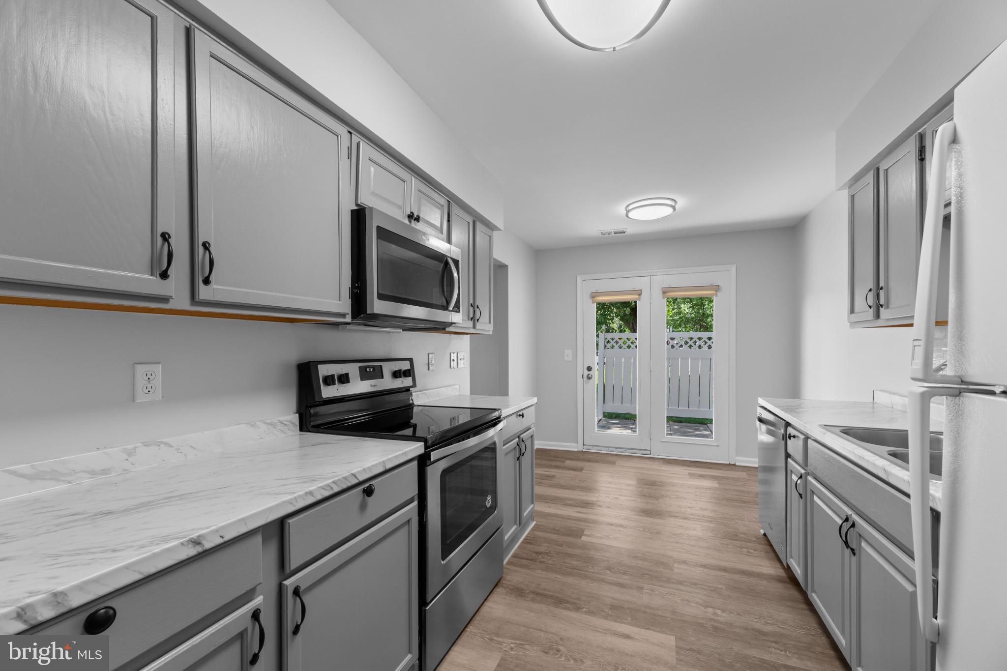 9302 Player Drive, Unit 155 Laurel, MD 20708 - Photo 13 of 43 a kitchen with stainless steel appliances granite countertop a stove a sink and a refrigerator