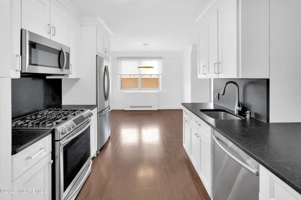 a kitchen with granite countertop a refrigerator and a sink