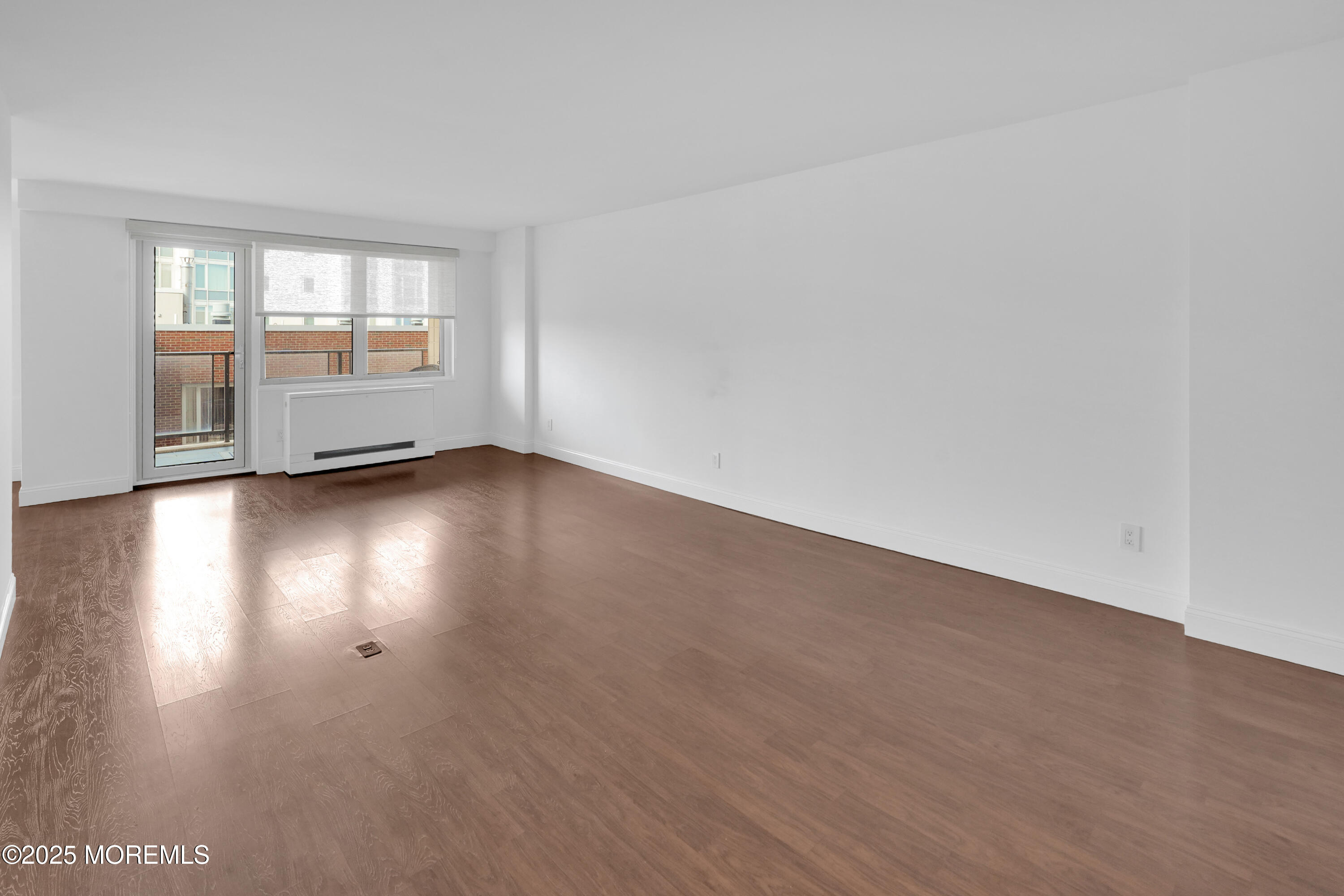 28 Riverside Avenue, Unit 5J Red Bank, NJ 07701 - Photo 11 of 35 a view of an empty room with wooden floor and a window