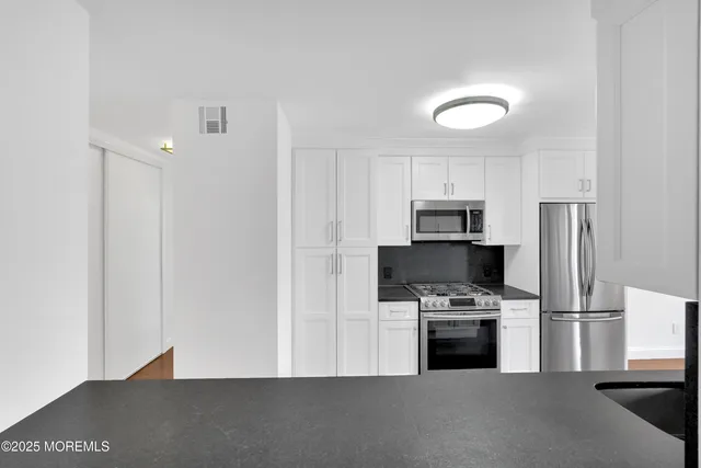 a kitchen with stainless steel appliances a refrigerator a stove a microwave and a refrigerator