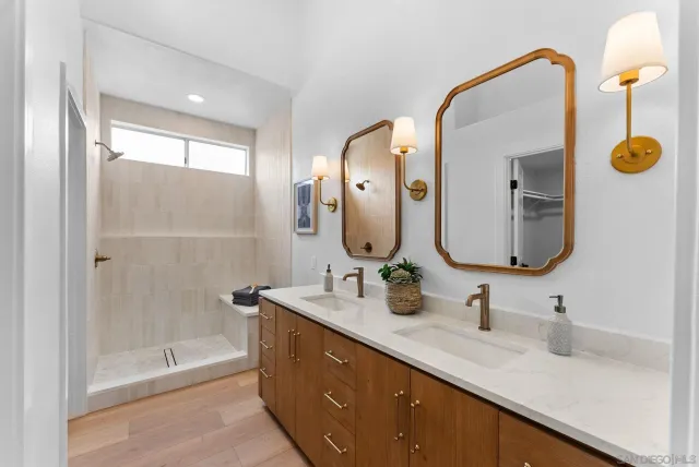 a bathroom with a double vanity sink mirror and shower
