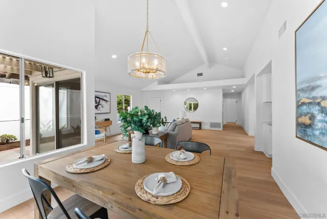 a view of a dining room with furniture a chandelier and wooden floor