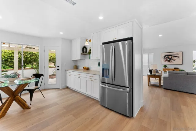 a kitchen with a refrigerator a dining table and chairs
