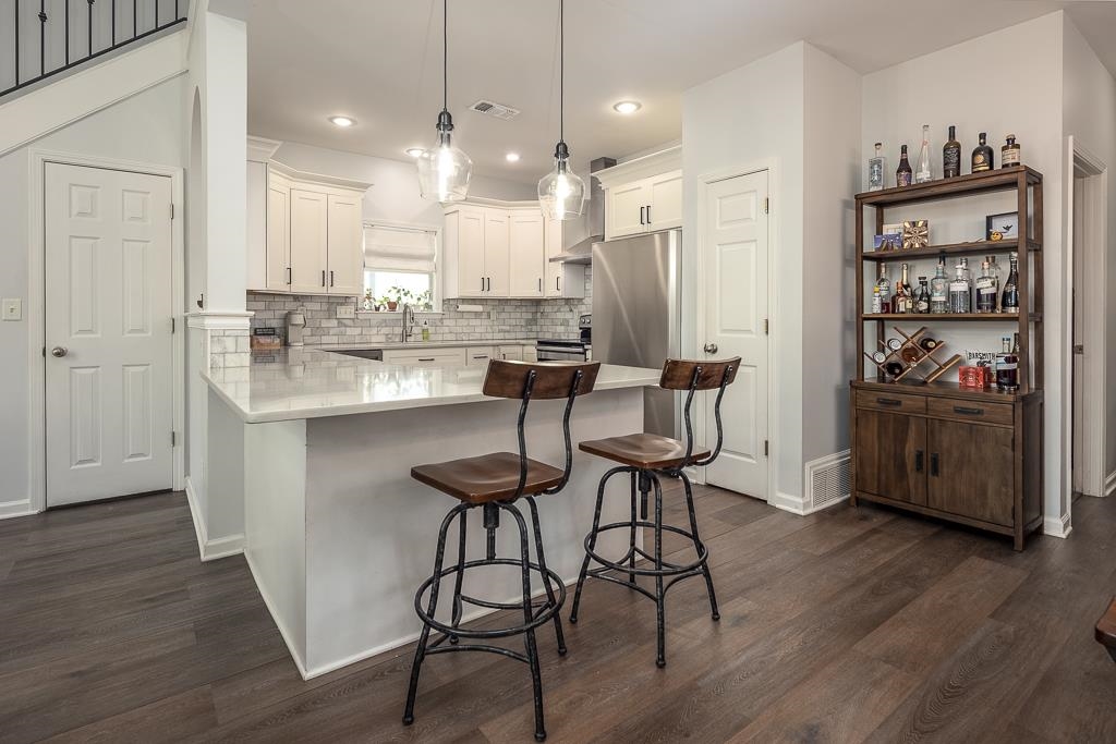 1290 Isle Pointe Drive Memphis, TN 38103 - Photo 10 of 30 a kitchen with stainless steel appliances kitchen island granite countertop a table chairs refrigerator and sink