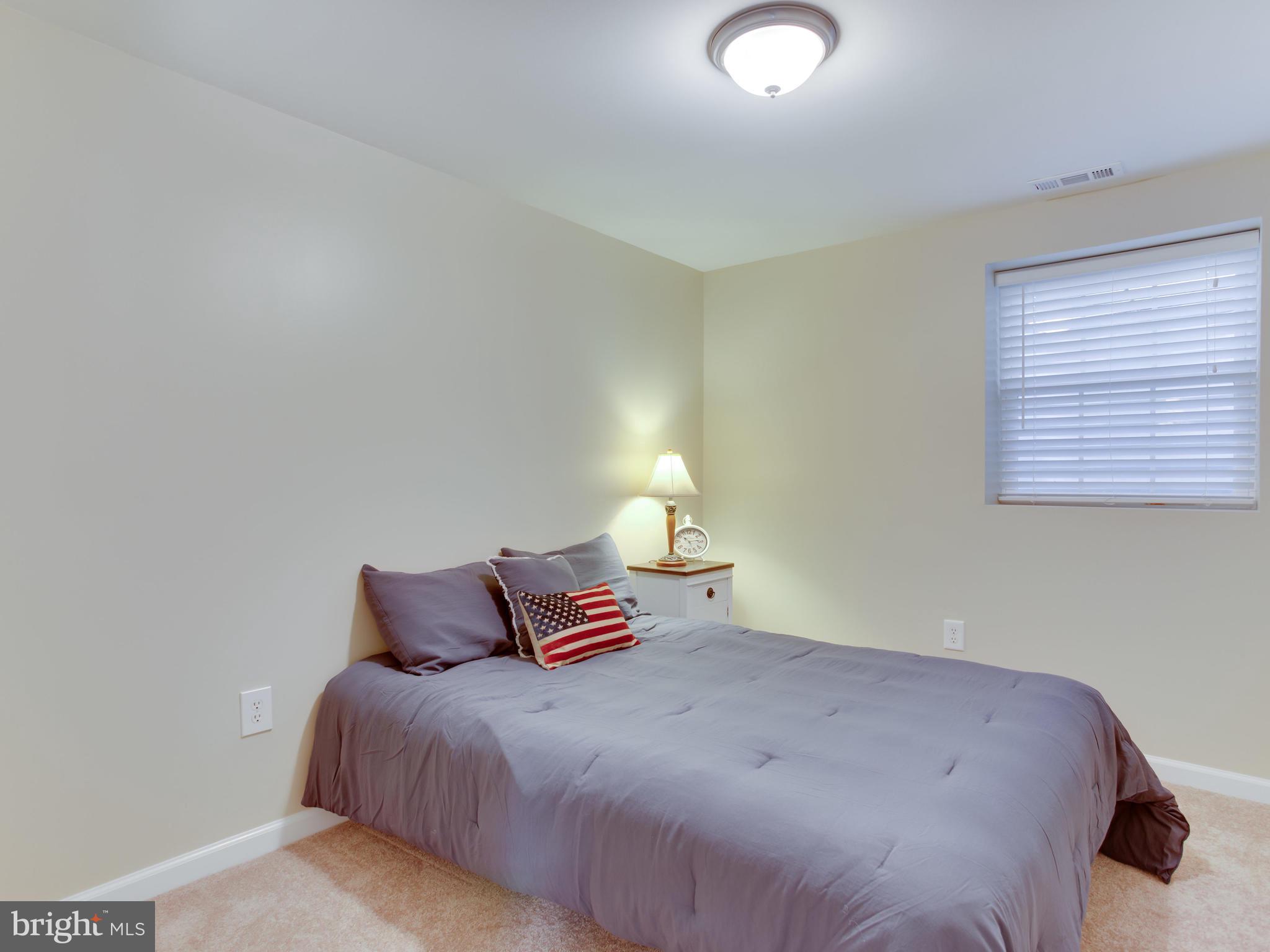 1925 Grant Road Baltimore, MD 21227 - Photo 31 of 44 a bedroom with a bed and a lamp