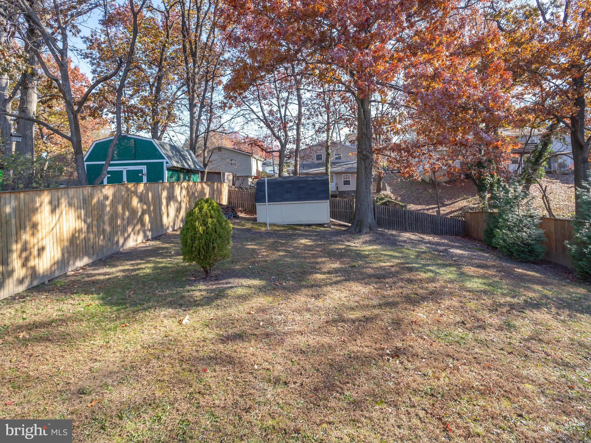 1925 Grant Road Baltimore, MD 21227 - Photo 43 of 44 a backyard of a house with large trees and a barn