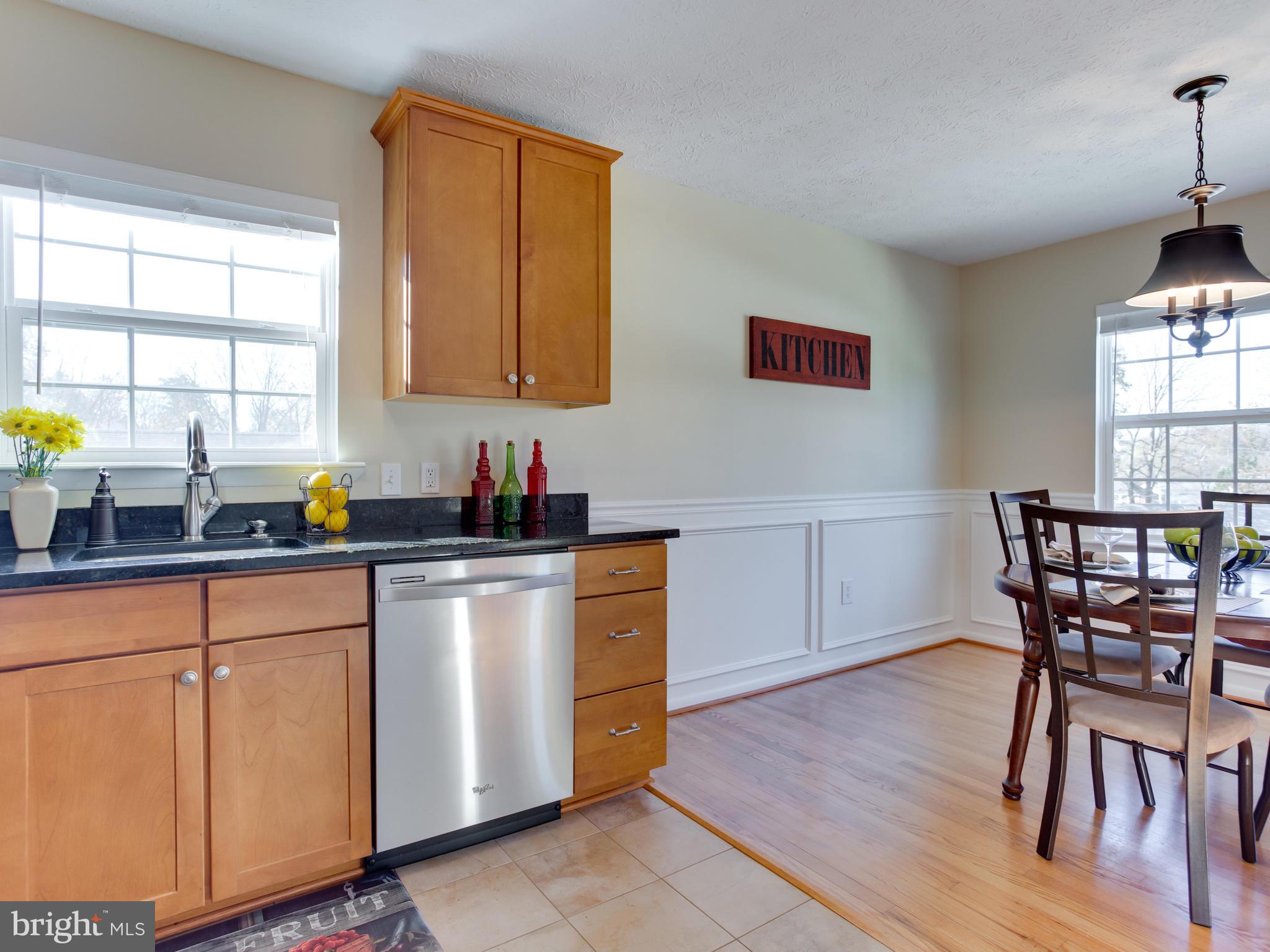 1925 Grant Road Baltimore, MD 21227 - Photo 9 of 44 a kitchen with stainless steel appliances granite countertop a stove a sink a dining table and chairs with wooden floor