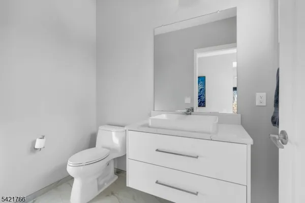 a bathroom with a sink toilet vanity and mirror