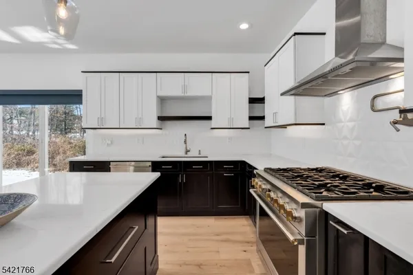 a kitchen with stainless steel appliances a sink a stove cabinets and a counter top space