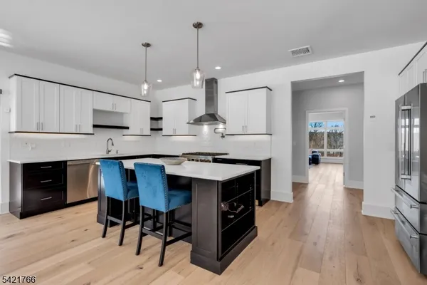 a kitchen with granite countertop a stove a sink a dining table and chairs