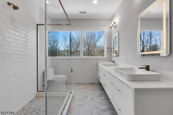 a spacious bathroom with a toilet sink and mirror