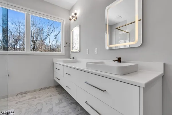 a bathroom with 2 sink and a mirror
