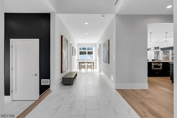 a view of a hallway with wooden floor and windows