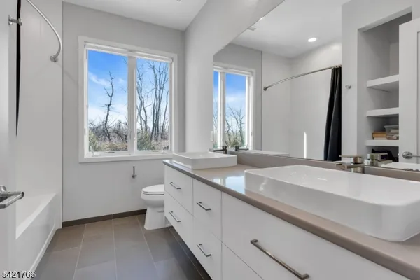 a bathroom with a granite countertop sink mirror and a bathtub