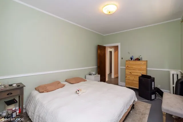 a bedroom with a bed and a refrigerator