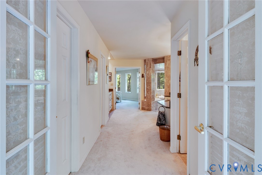 1167 Ottoman Ferry Road Lancaster, VA 22503 - Photo 21 of 52 Hallway with light-toned carpet flooring and neutr