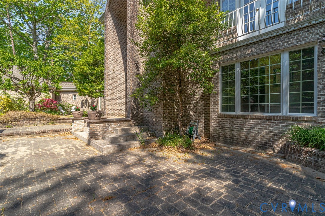 1167 Ottoman Ferry Road Lancaster, VA 22503 - Photo 8 of 52 Brick exterior with multi-pane windows and a secon