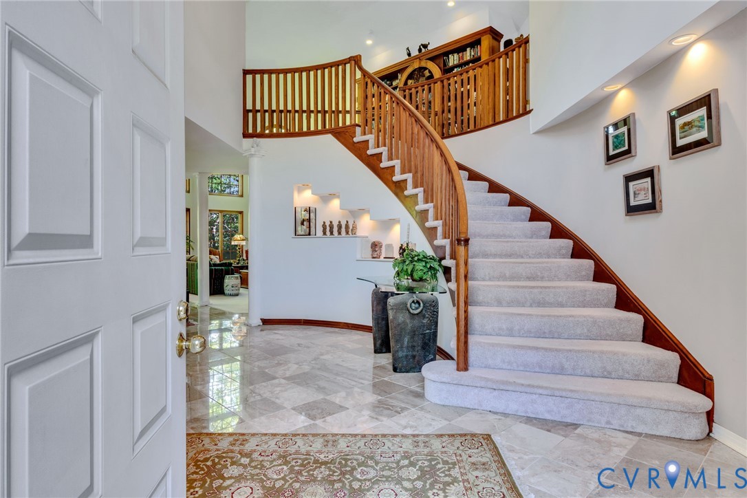 1167 Ottoman Ferry Road Lancaster, VA 22503 - Photo 10 of 52 Grand entry featuring a curved staircase with wood