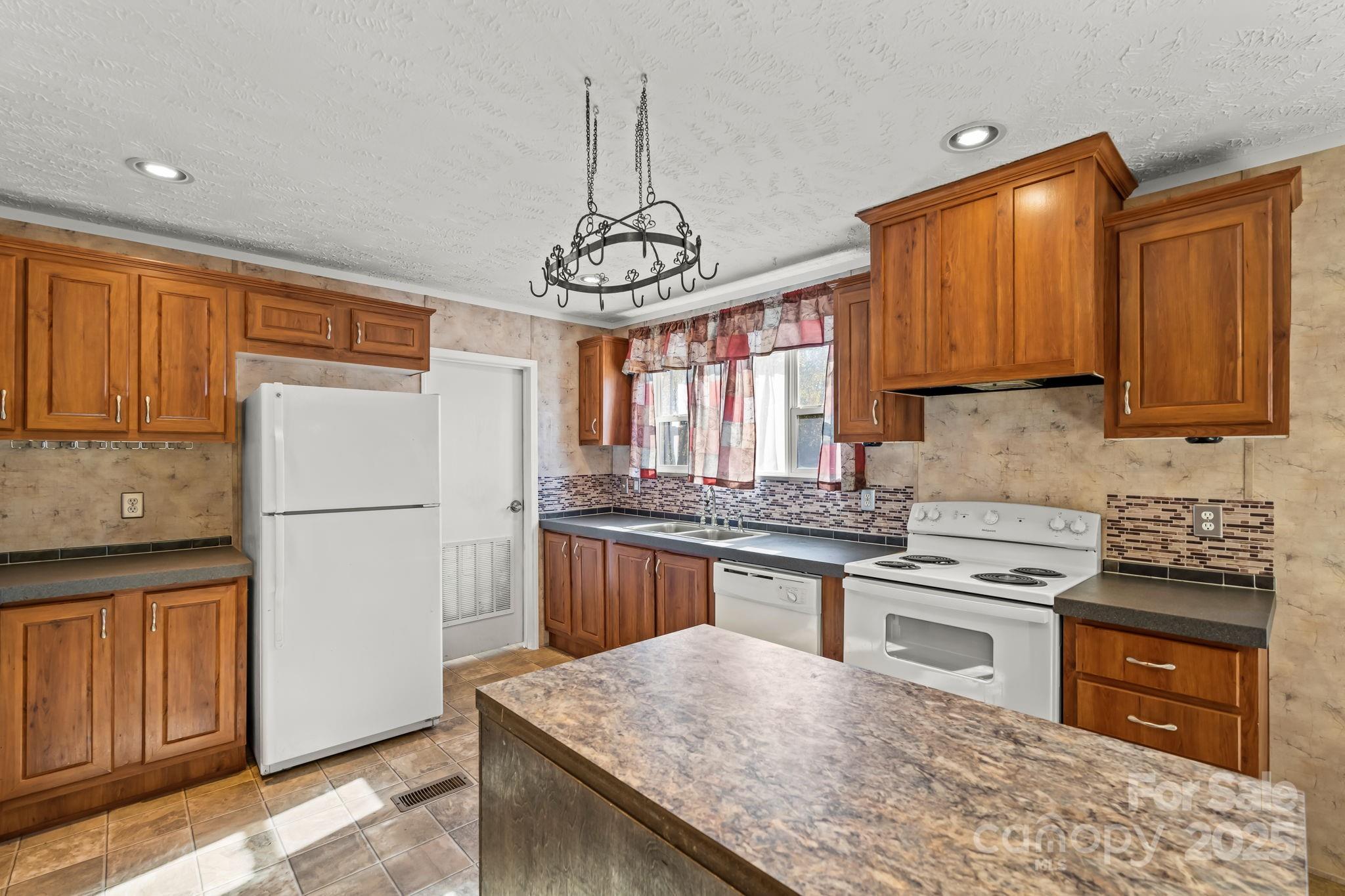 1060 Beckham Road Salisbury, NC 28147 - Photo 12 of 28 a kitchen with stainless steel appliances granite countertop wooden cabinets a stove a sink and a refrigerator