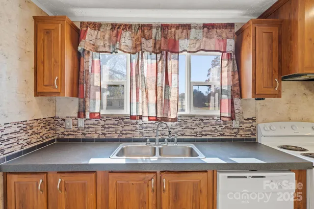 a kitchen with stainless steel appliances a sink window and cabinets